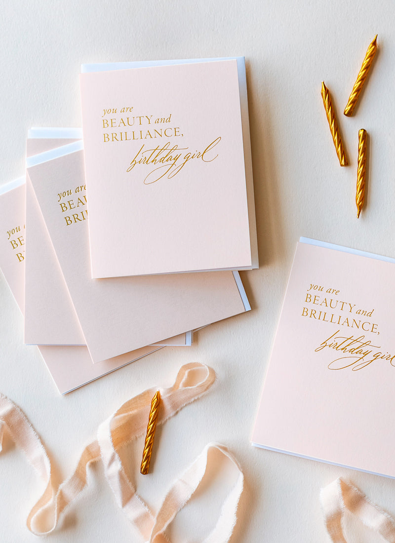 Overhead view of pink greeting cards with gold foil.