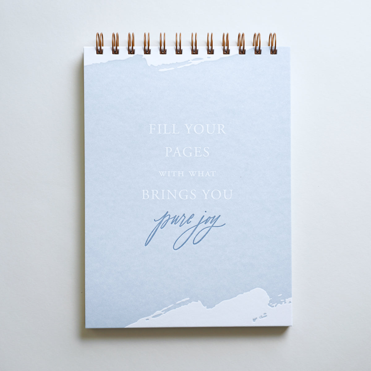 &quot;Pure Joy&quot; lined notebooks are letterpress printed by hand in light blue ink.